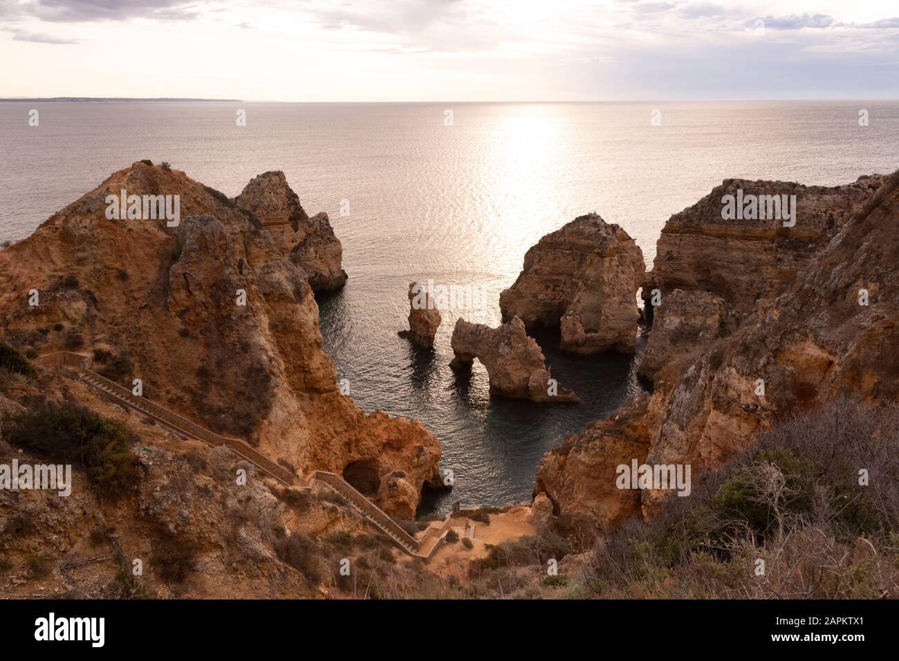 Portugal, Faro District, Lagos, Küstenklippen und Naturbogen bei Sonnenaufgang Stockfoto
