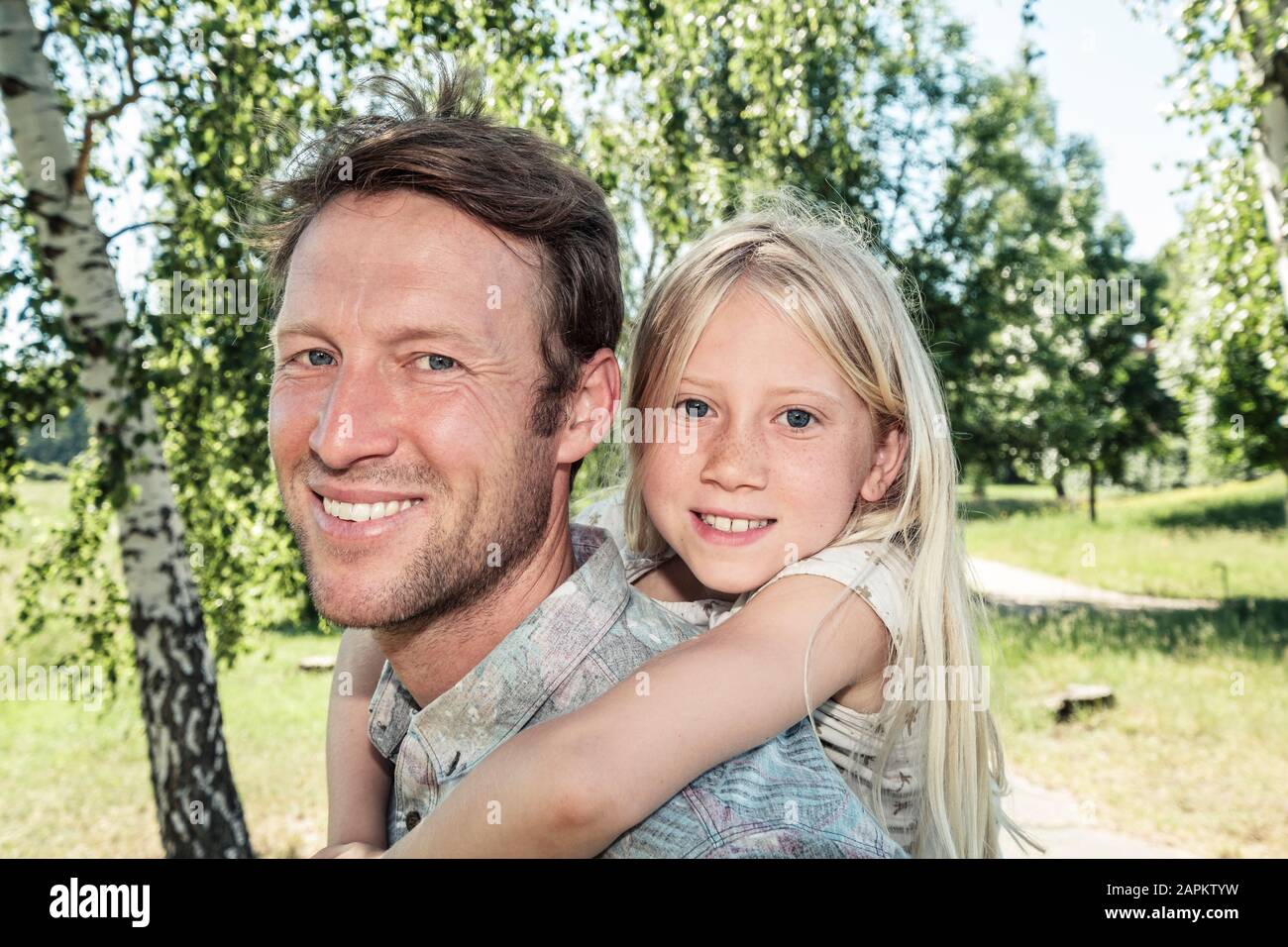 Porträt der glückliche Vater mit Tochter piggyback Stockfoto