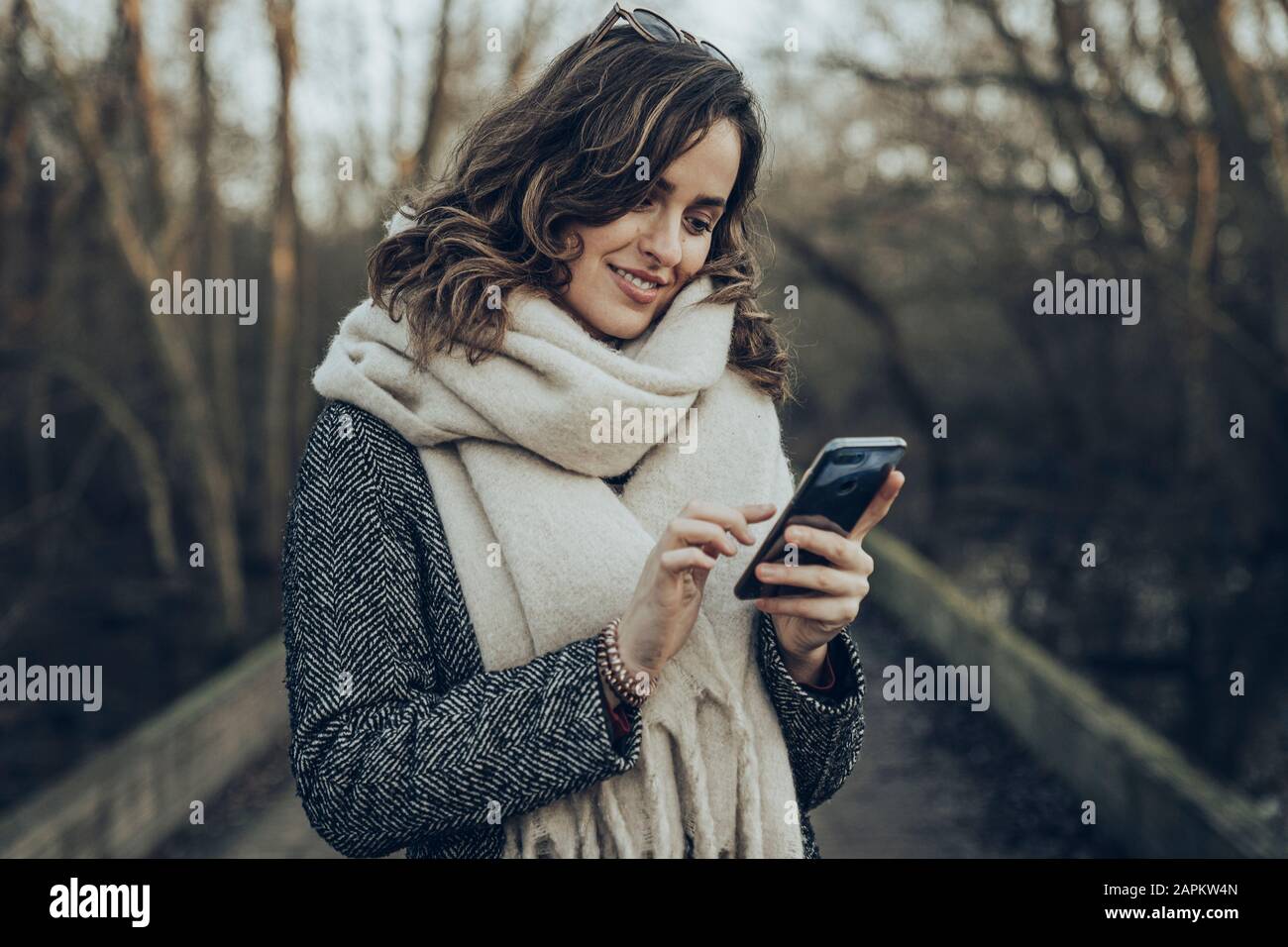 Portrait junger brünette Frau mit Smartphone Stockfoto