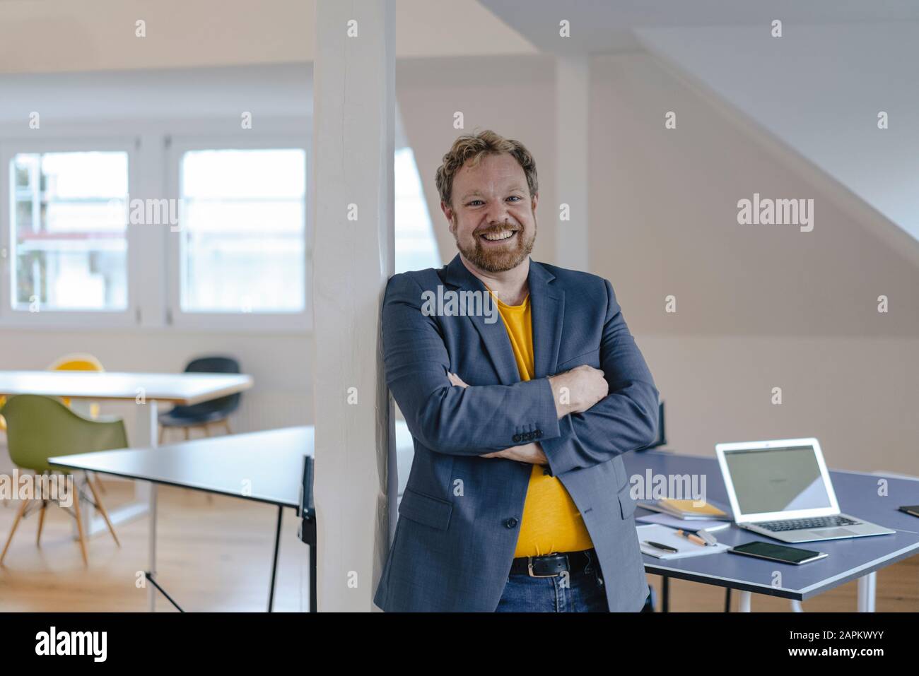 Porträt eines lächelnden Geschäftsmannes im Büro mit Tischtennisplatte Stockfoto