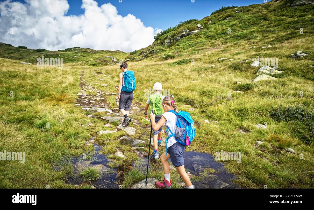 Mutter mit zwei Kindern, die in alpiner Landschaft, Passeiertal, Südtirol, Italien wandern Stockfoto