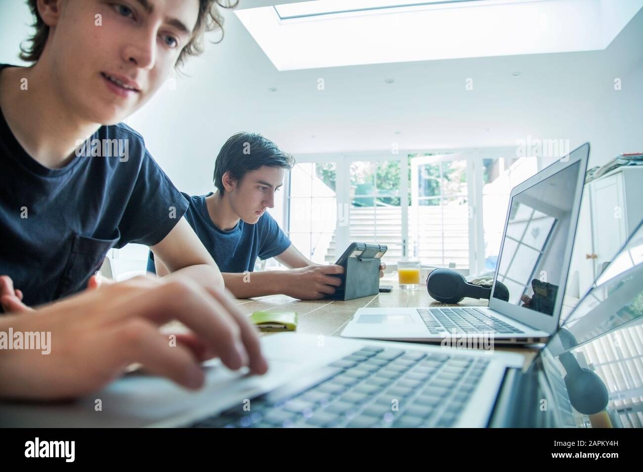 Zwei Teenager, die zu Hause Laptop und Tablet verwenden Stockfoto