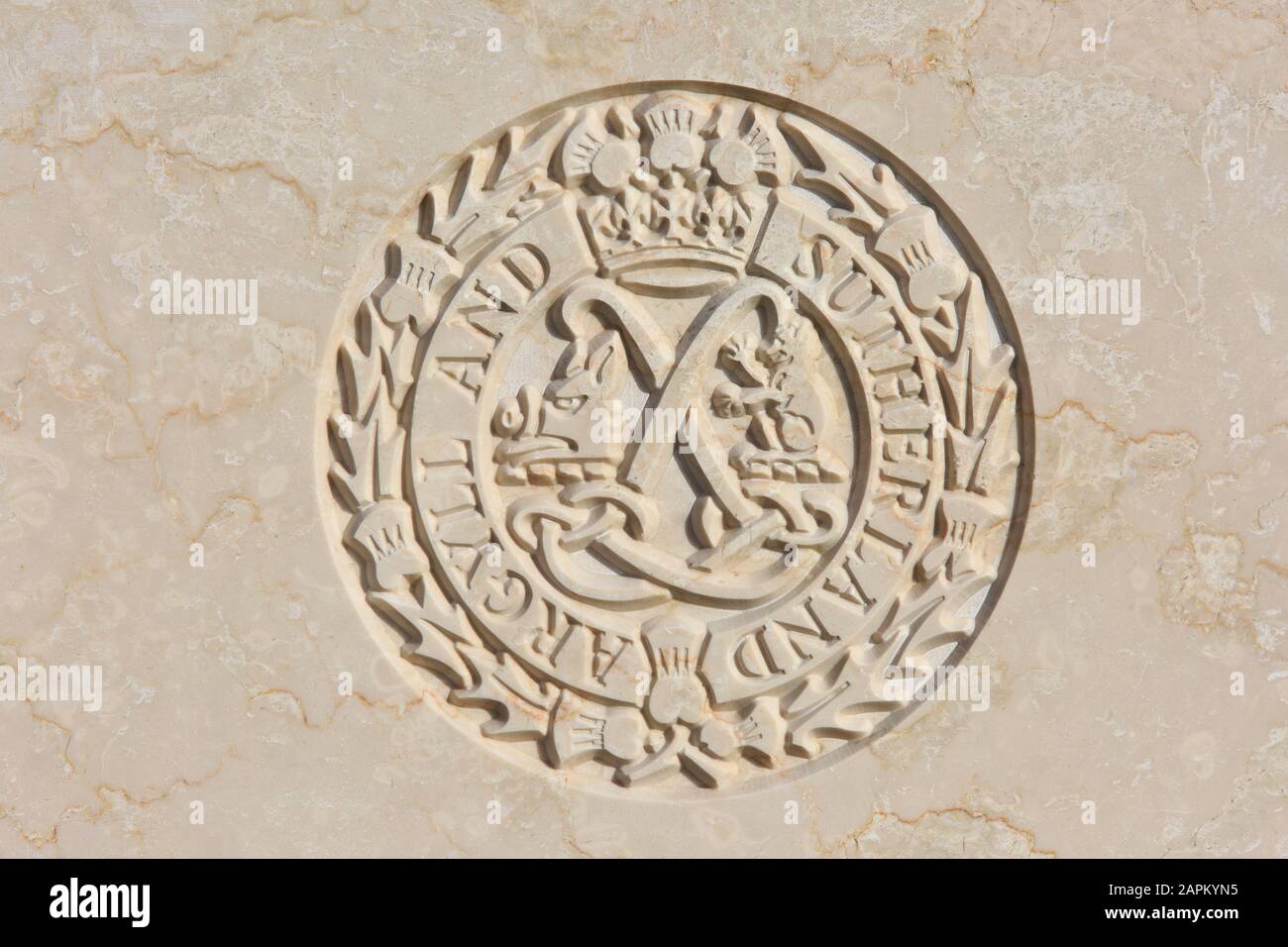 Das Regimentsemblem "Argyll and Sutherland Highlanders" (1881-heute) auf einem Kopfstein aus dem ersten Weltkrieg auf dem Tyne Cot Cemetery in Zonnebeke, Belgien Stockfoto