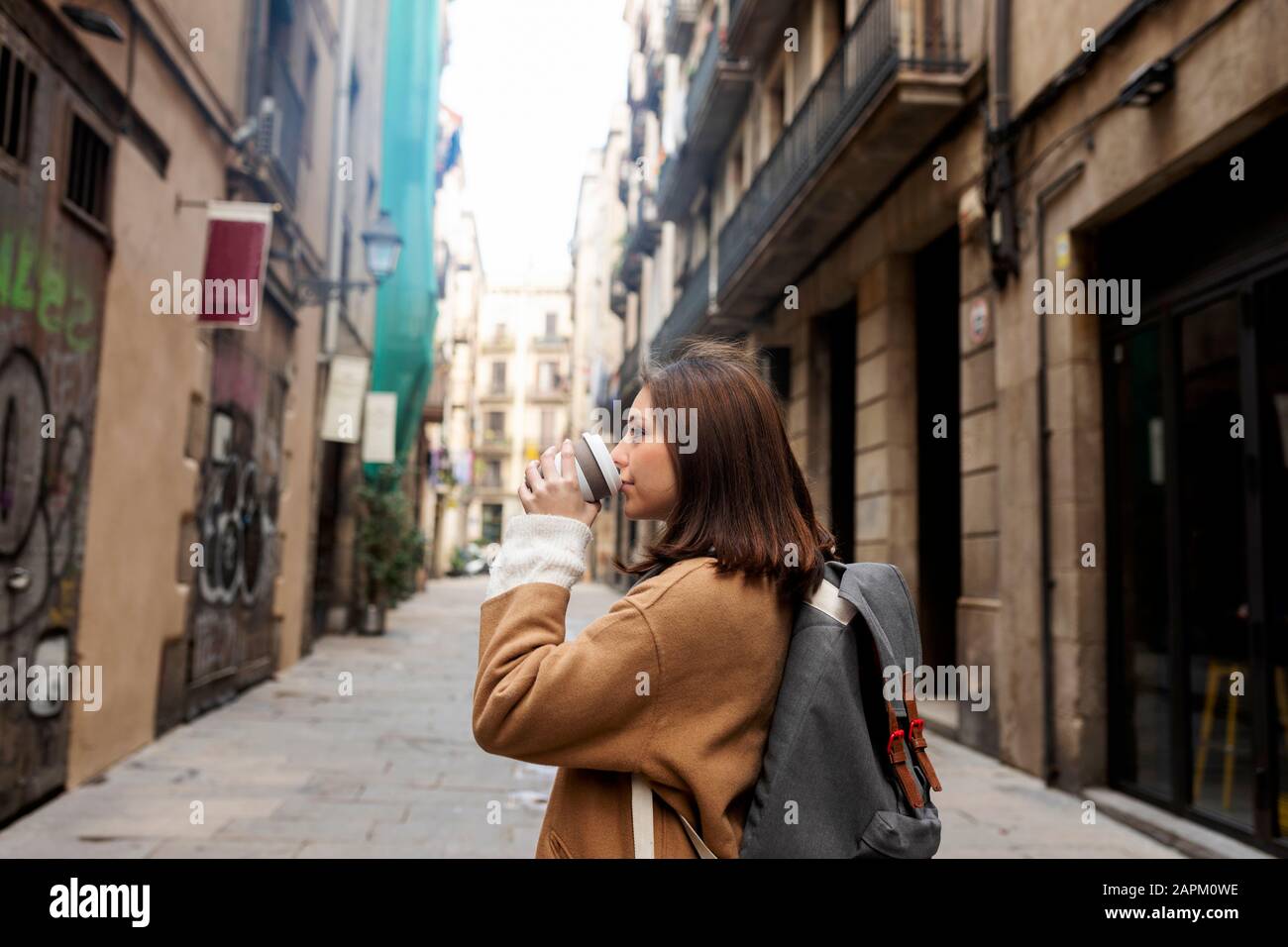 Junge Frau mit Kaffee zum Mitnehmen in Barcelona, Spanien Stockfoto
