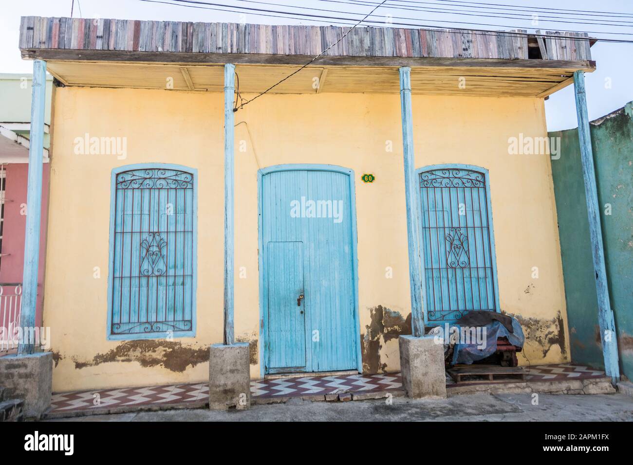 Ein Haus mit türkis bemalten Türen und Fenstern und gelber Außenansicht; Santiago de Cuba, Kuba. Stockfoto