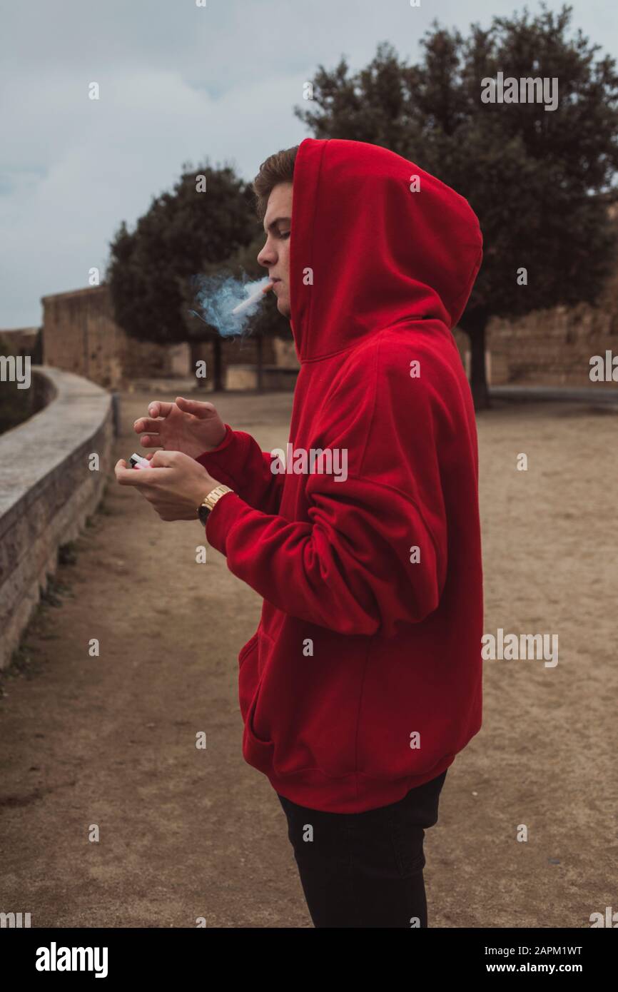 Blonder junger Mann raucht in Lleida eine Zigarette Stockfoto