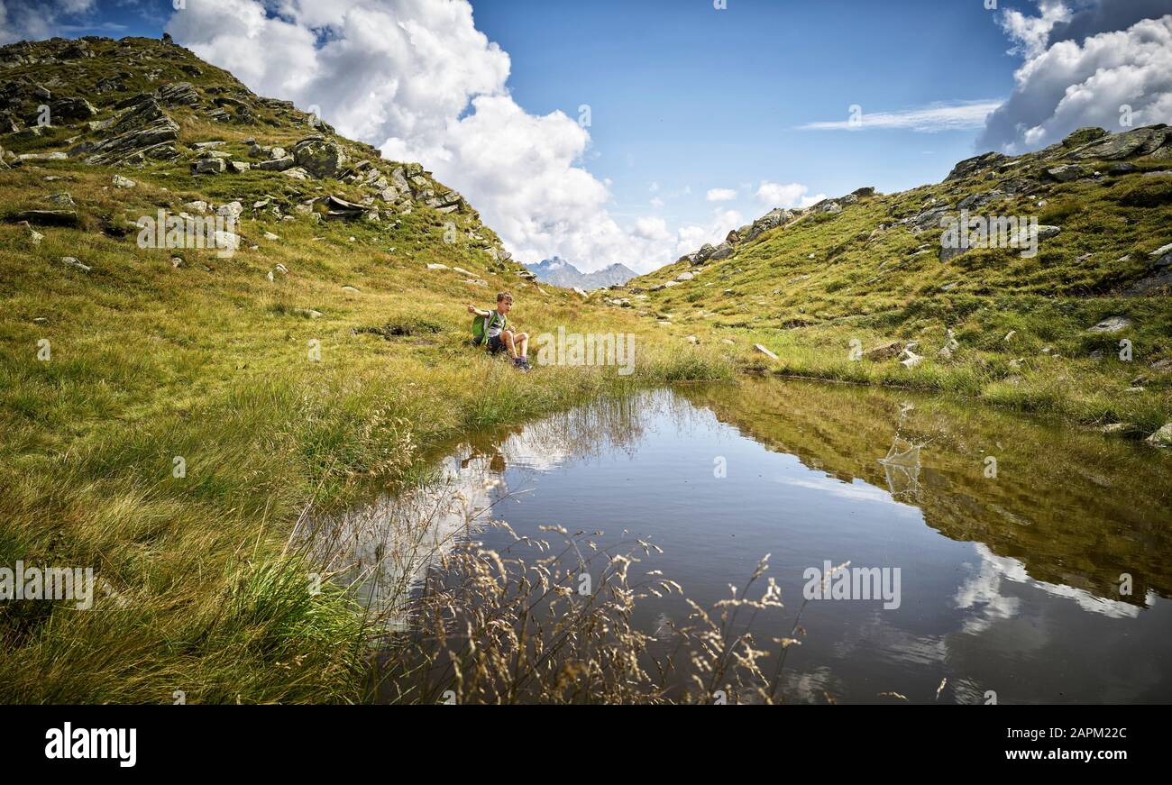 Junge, die eine Pause vom Wandern am Bergsee, Passeiertal, Südtirol, Italien, einlegen Stockfoto