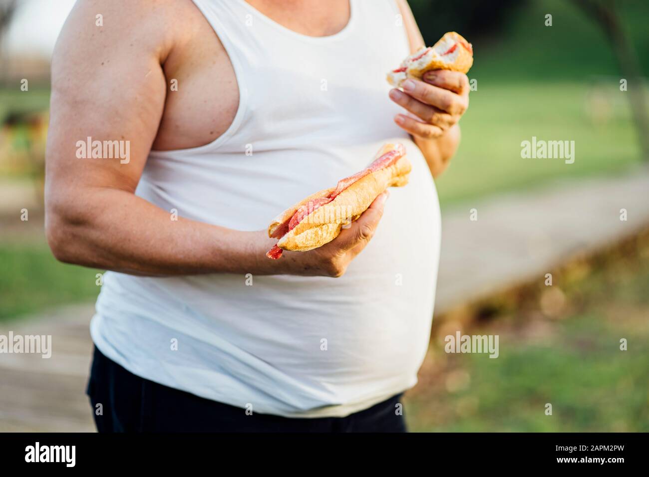 Mann mit Bierbauch, der Sandwich hält Stockfoto