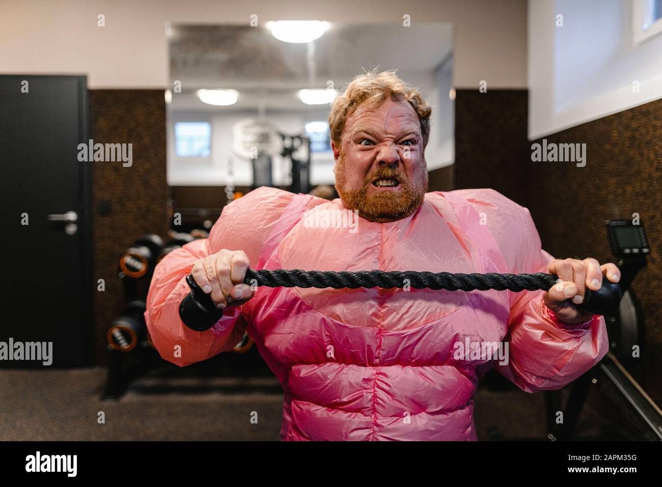 Mann mit pinkfarbenem Bodybuilder-Kostüm in der Sporthalle Stockfoto