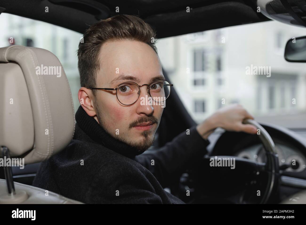 Porträt des jungen Autofahrers mit Brille Stockfoto