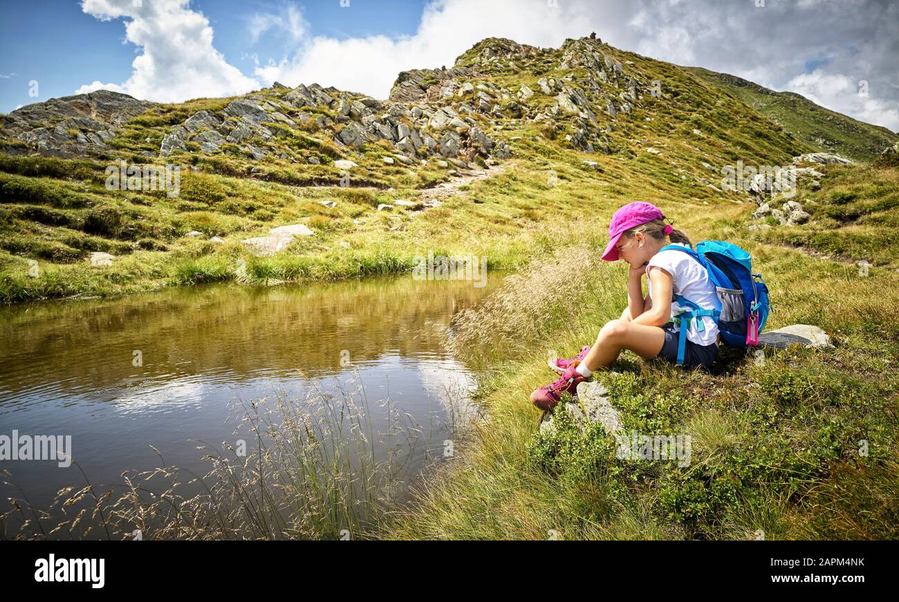 Mädchen, die eine Pause vom Wandern am Bergsee, Passeiertal, Südtirol, Italien, einlegen Stockfoto