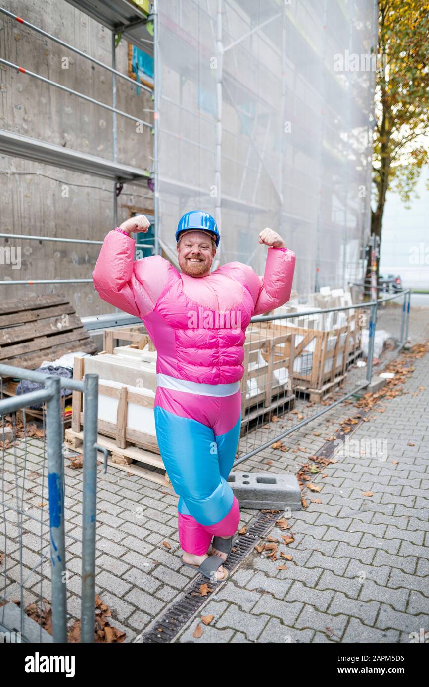 Porträt eines stolzen Mannes mit pinkfarbenem Bodybuilder-Kostüm und Hut auf der Baustelle Stockfoto