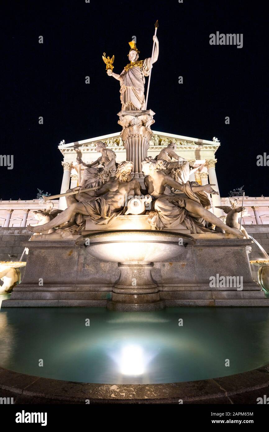 Österreich, Wien, Pallas Athena-Brunnen vor dem Parlamentsgebäude bei Nacht beleuchtet Stockfoto