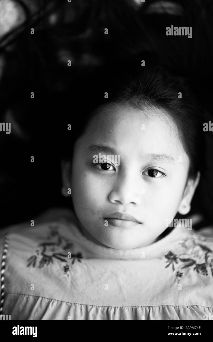 Portrait asiatischer junger Mädchen mit langen Haaren, die mit ernsthaftem Gesicht an der Kamera aussehen. Stockfoto