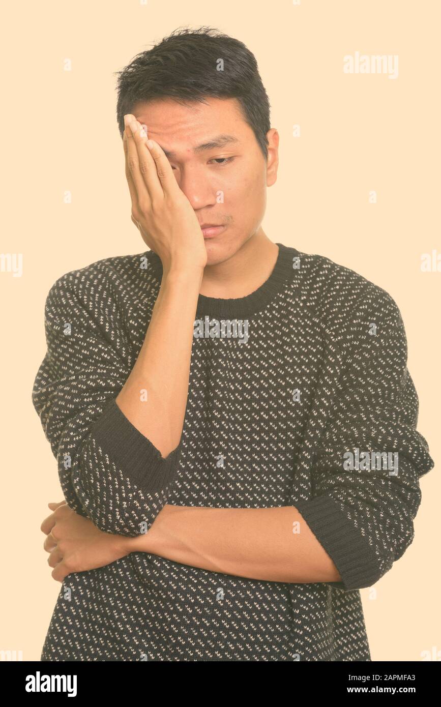 Studio shot junger asiatischer Mann müde Stockfoto
