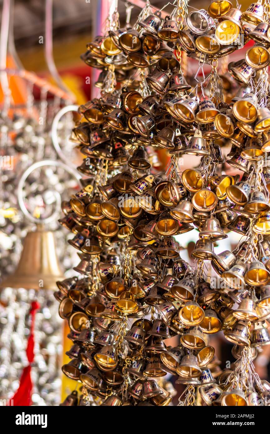 Viele kleine Goldglocken hängen an Kette im buddhistischen Tempel. Ang Thong, Thailand, 16. Februar 2019 Stockfoto