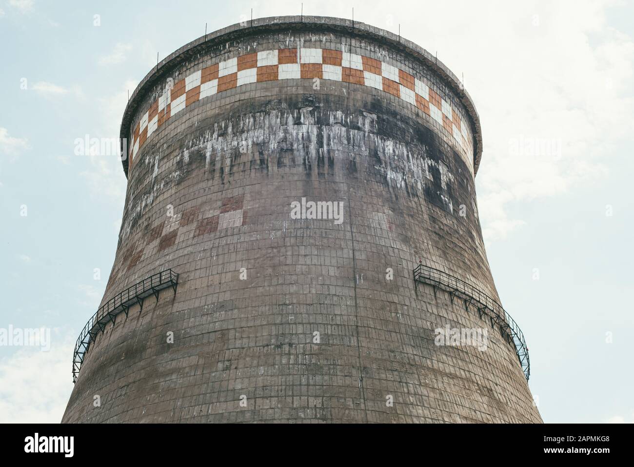 Unglaublich riesiger, alter, industrieller Kamin aus Betonblöcken. Konzept des Umweltschutzes und der Naturpflege. Stockfoto