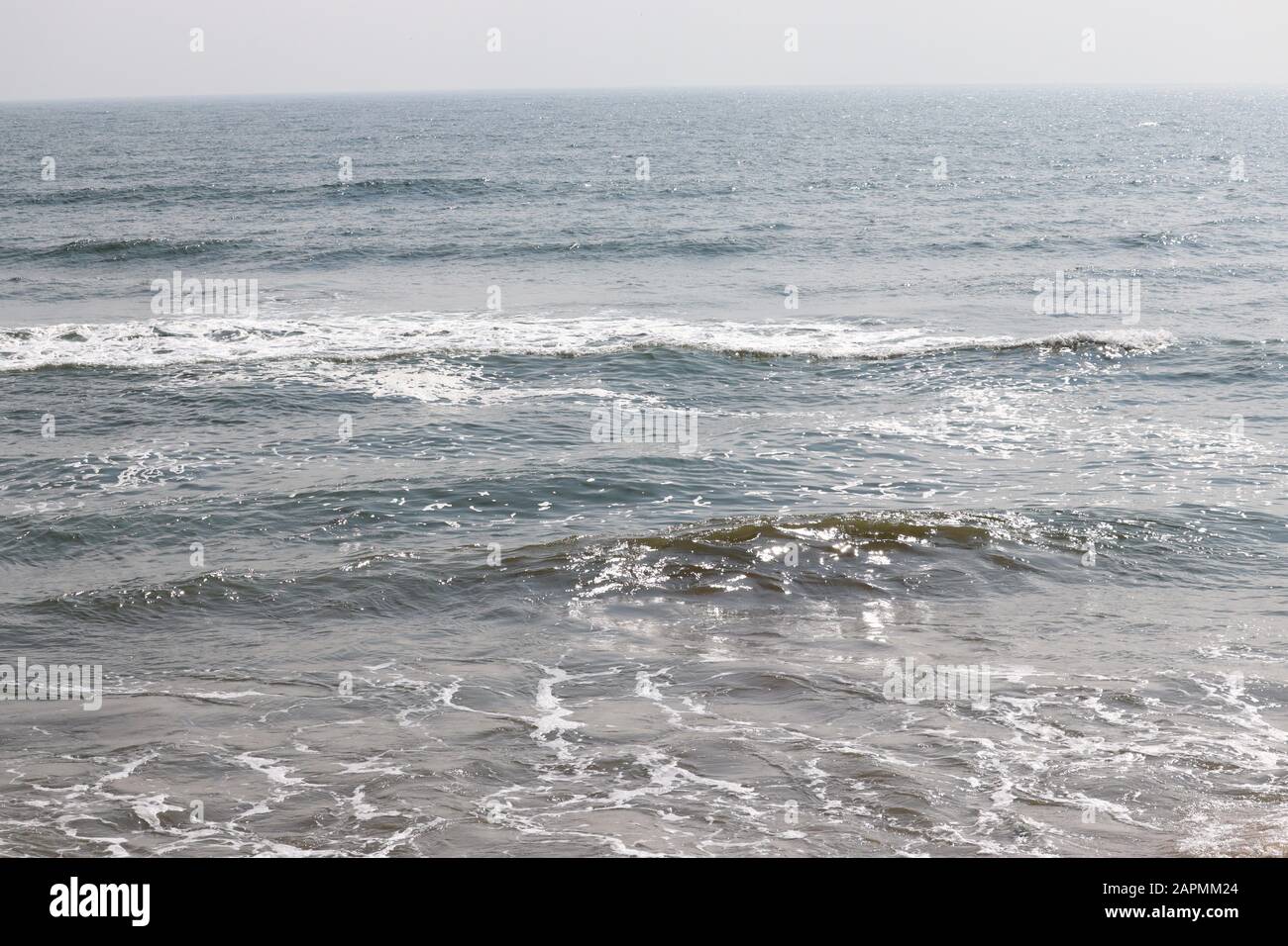 Abstrakter Unschärfe-Hintergrund, Natur des tropischen Sommerstandes mit Sonnenstrahlen. Goldener Sandstrand, Meerwasser gegen blauen Himmel mit weißen Wolken. Cop Stockfoto