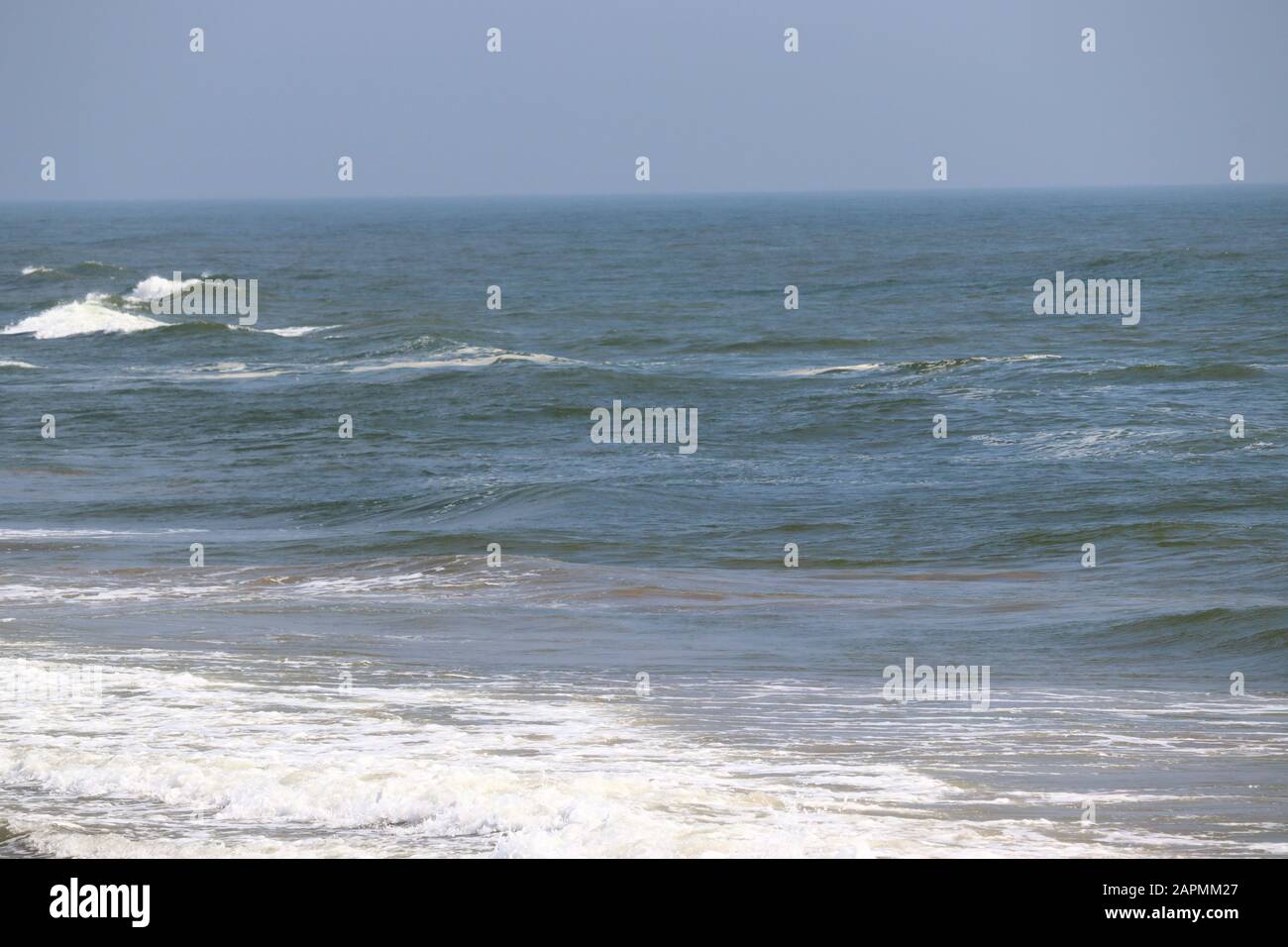 Abstrakter Unschärfe-Hintergrund, Natur des tropischen Sommerstandes mit Sonnenstrahlen. Goldener Sandstrand, Meerwasser gegen blauen Himmel mit weißen Wolken. Cop Stockfoto