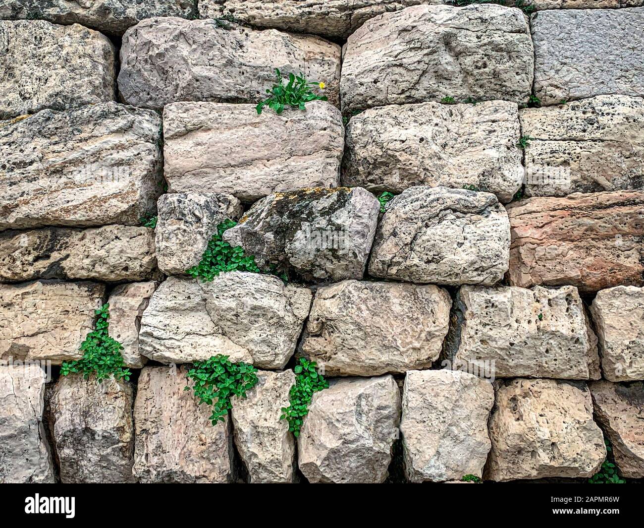 Alte Steinmauer aus großen Kalksteinen in Athen, Region Attika in Griechenland. Riesige, antike Steinblöcke, die zu einer Mauer gehäuft wurden. Foto. Stockfoto
