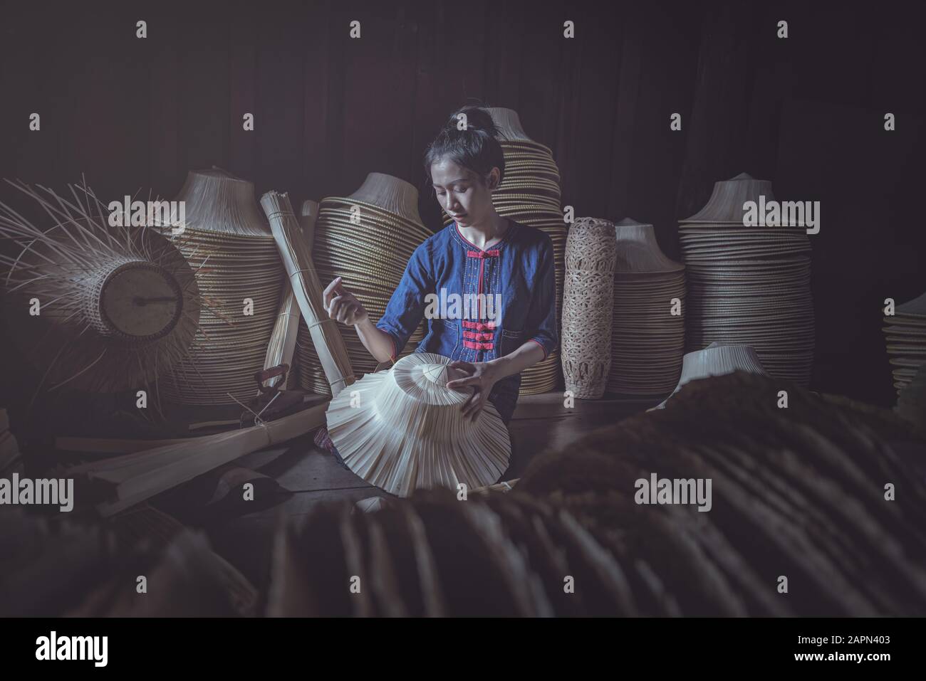 Frau In Ethnischen Traditionellen Völkern Nationales thailändisches Kostüm Weaving Hüte. Hüte, die aus Palmblättern gewebt werden. Stockfoto