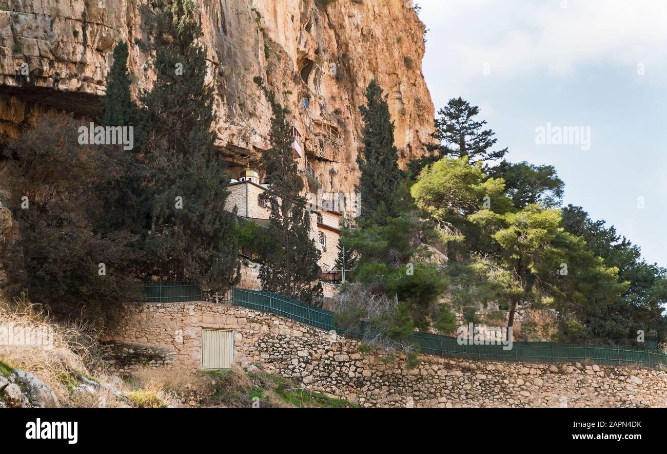 Das alte kloster faran klammert sich an die Kuppe von wadi qelt bei einem prälat am Westufer vor einer großen Naturhöhle Stockfoto