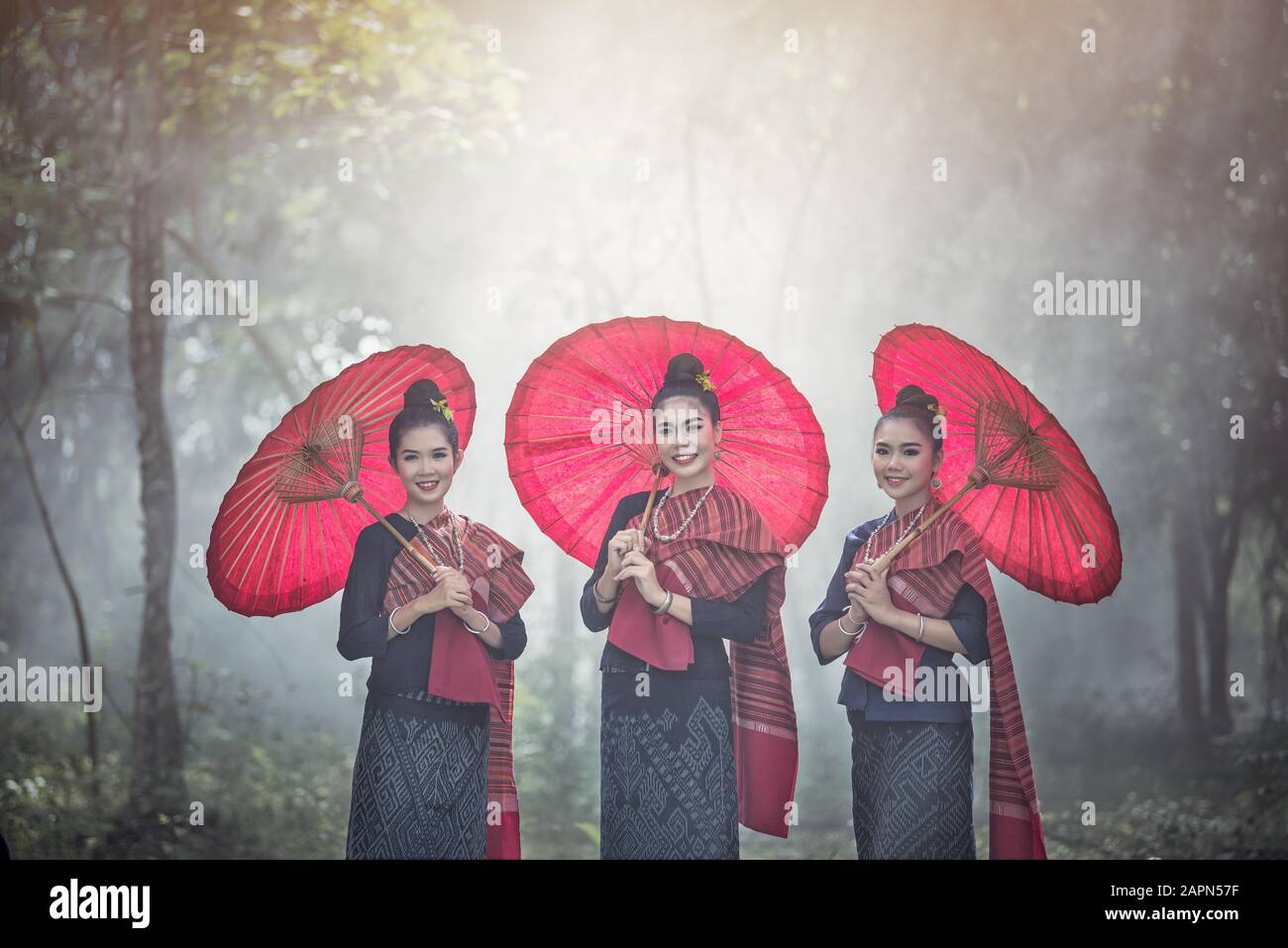 Porträt der Schönen thailändischen Frauen in Phu-Thai Tracht, Handgefertigter Regenschirm, der Vintage-Stil in Thailand macht Stockfoto