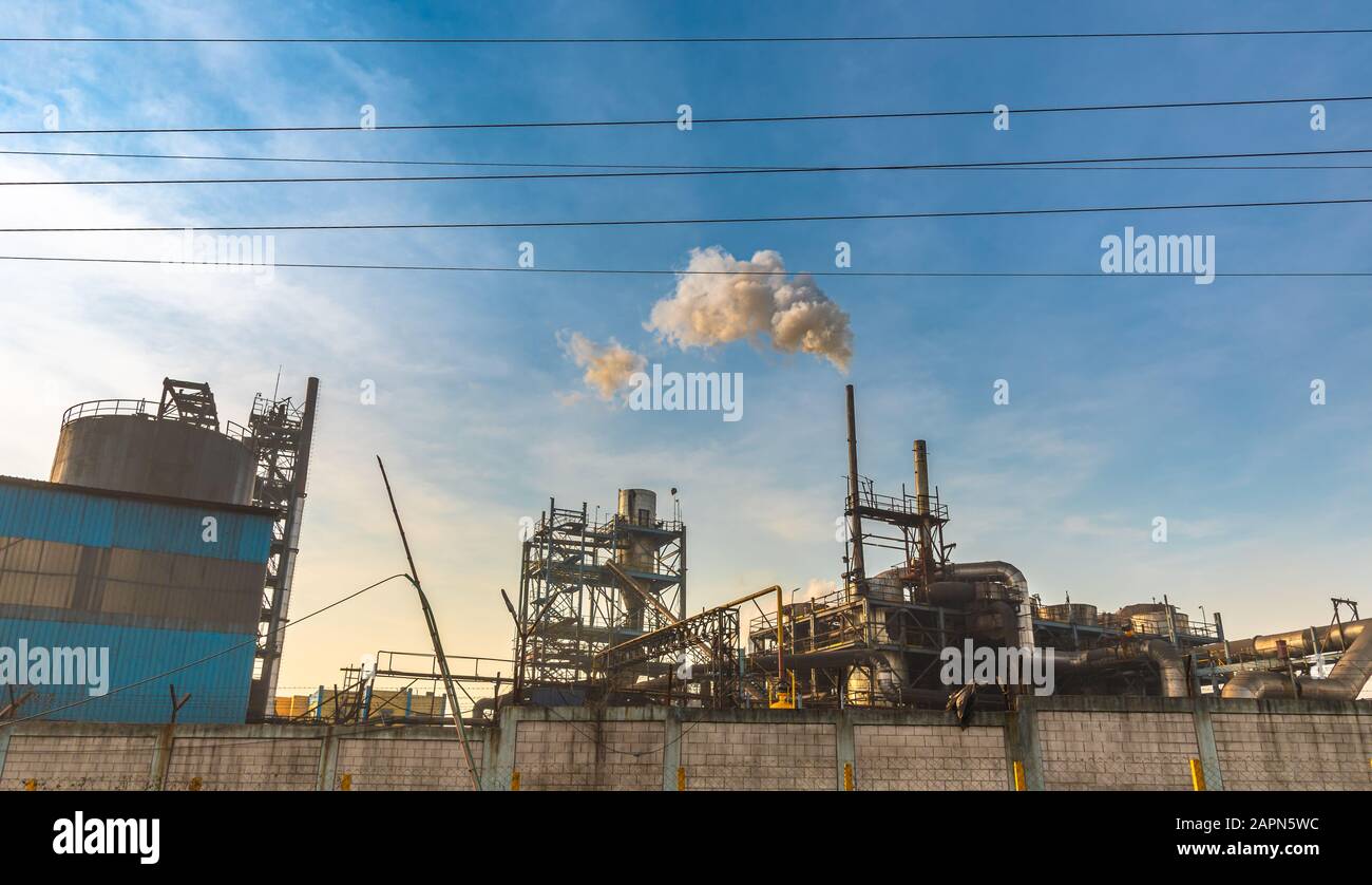 Verschmutzter Rauch, der aus dem Schornstein einer Kleinindustrie austritt. Stockfoto