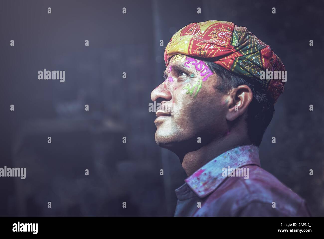 Mathura, INDIEN - Februar 25.2018: Porträt eines indianischen Mannes, das mit Farben auf dem Gesicht verschmiert ist, posiert für ein Foto während der Holi-Festfeier Stockfoto