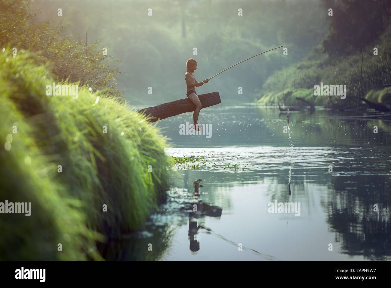Asiatischer Junge am Fluss angeln Stockfoto