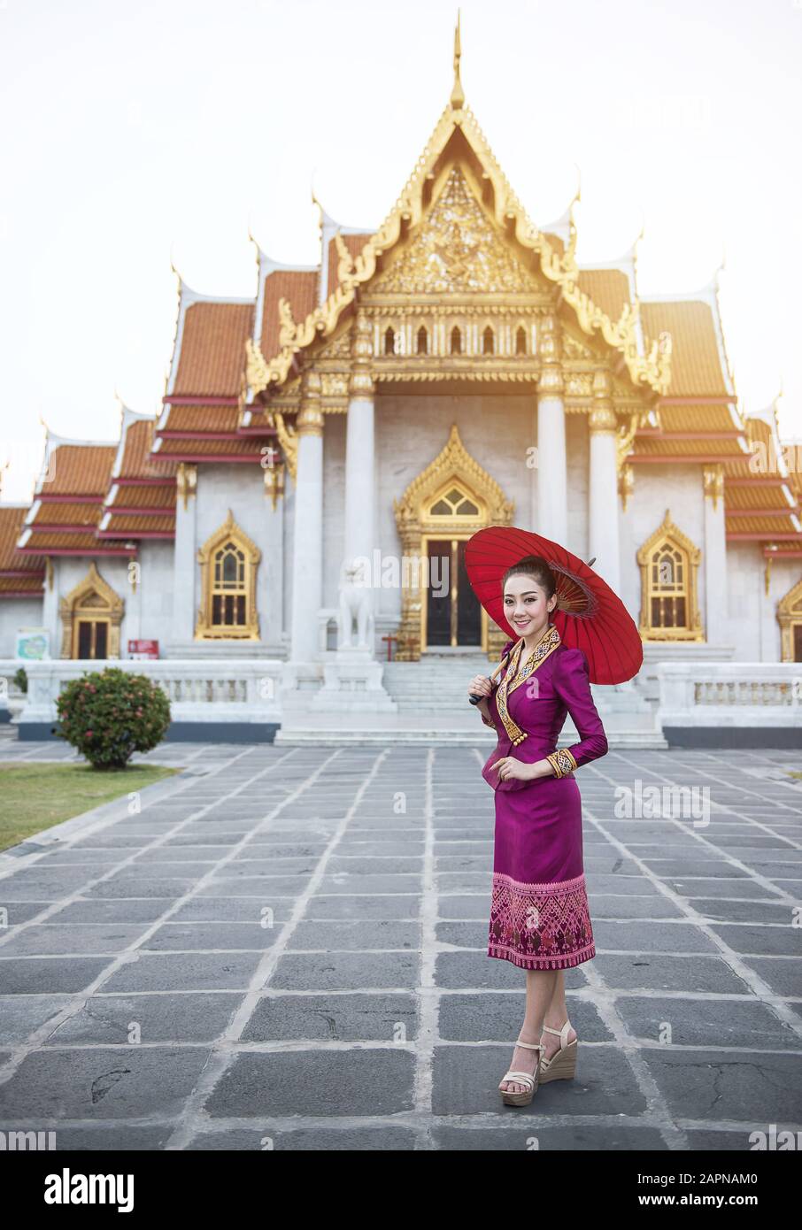 Frau Touristin mit rotem traditionellen thailändischen Regenschirm im Wat Benchamabophit, dem Marmortempel in Bangkok, Thailand Stockfoto