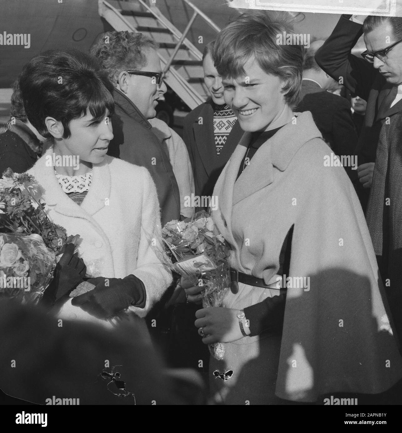 Ankunft der Eisstars in Schiphol Petra Burka (l.) und Sjoukje Dijkstra Anmerkung: Abends würden die Eisstars auf der Haager Eisbahn auftreten Datum: 28. Oktober 1965 Ort: Noord-Holland, Schiphol Keywords: An- und Abreise, Blumen, Eistanzen, Eiskunstlauf persönlicher Name: Burka, Petra, Dijkstra, Sjoukje Stockfoto