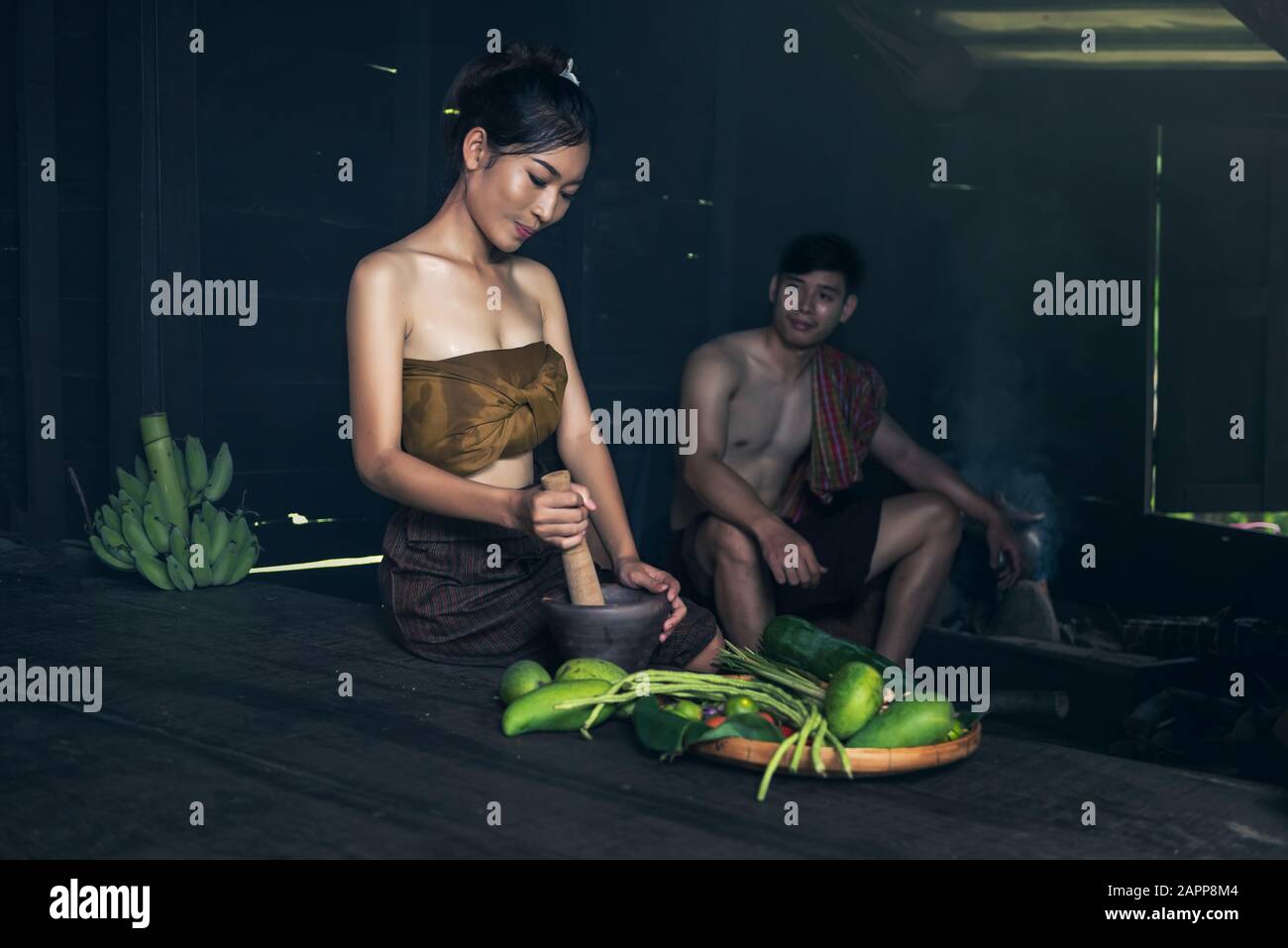 Asiatische Frau, die Papaya-Salat auf der heimischen Landschaft Thailands kocht Stockfoto
