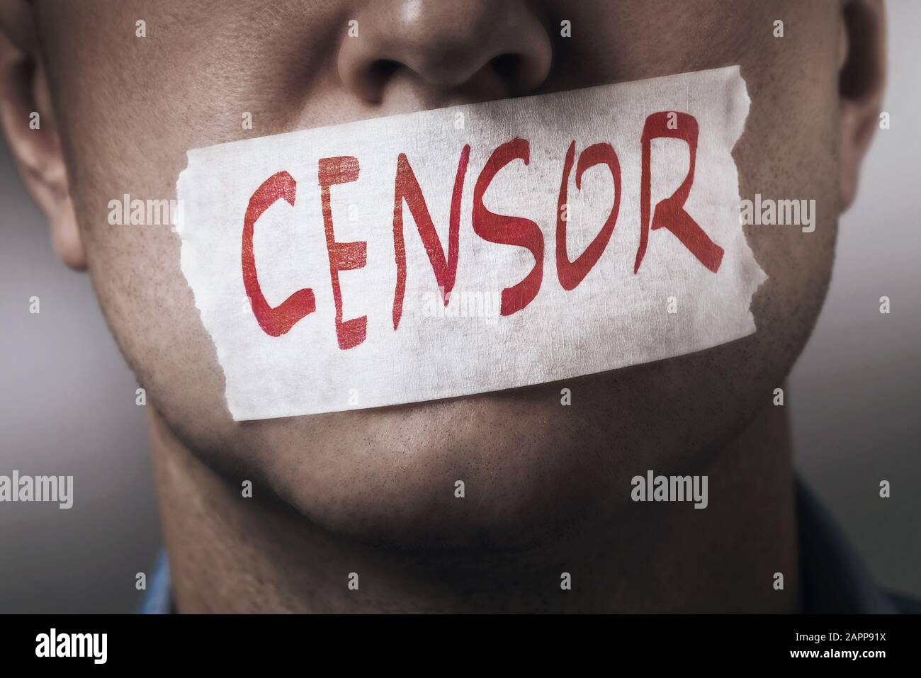 Der Mund eines Menschen ist mit Abdeckband abgedichtet, Nahaufnahme. Das Konzept der Zensur in der Gesellschaft. Stockfoto