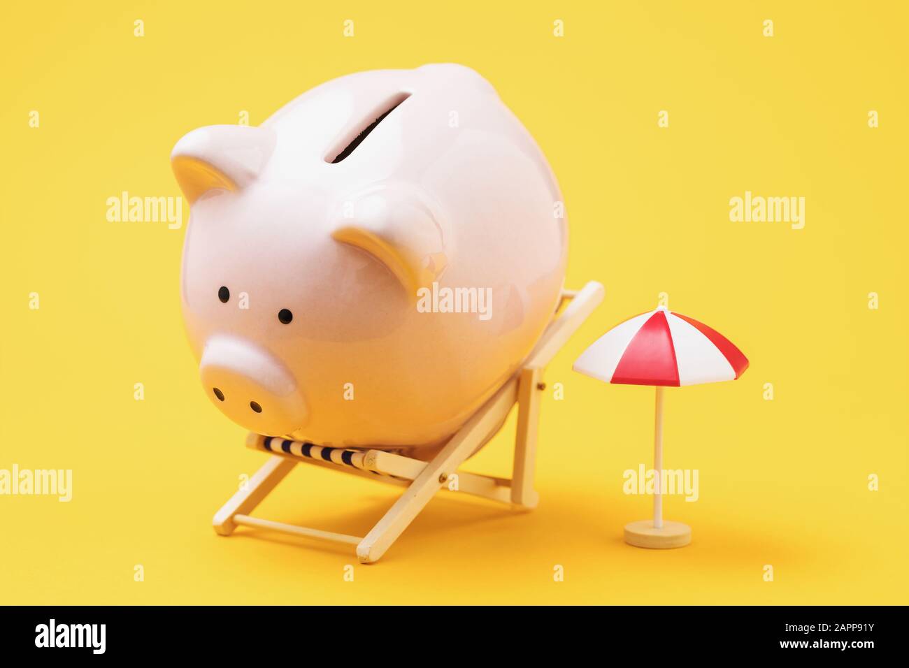 Schweinebank in einem Liegestuhl und einem Sonnenschirm auf gelbem Hintergrund. Konzept Zur Ansammlung Von Urlaubsgeldern Stockfoto