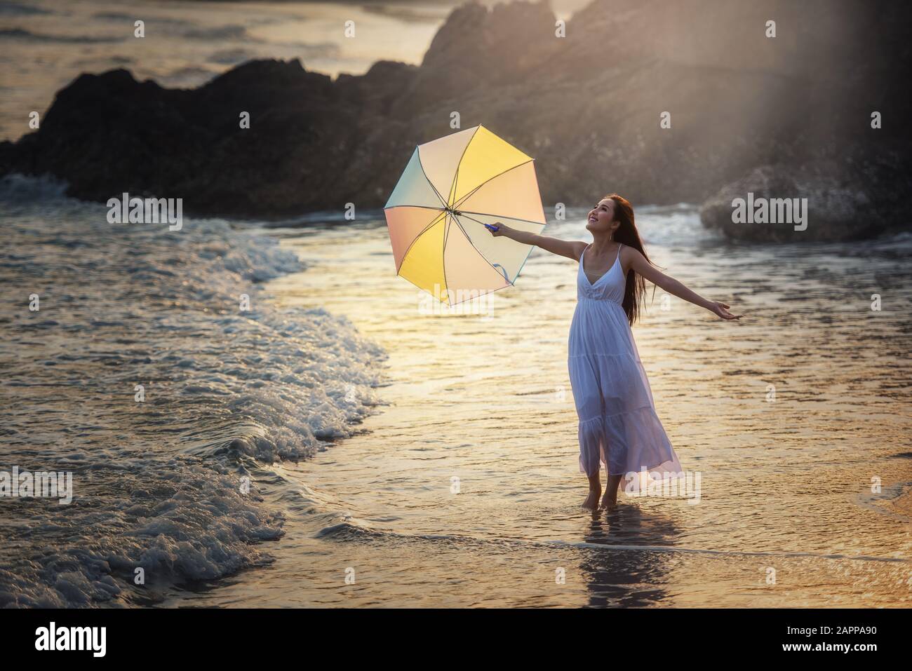 Fröhliche unbeschwerte Frau schönen Sonnenuntergang am Strand genießen Stockfoto