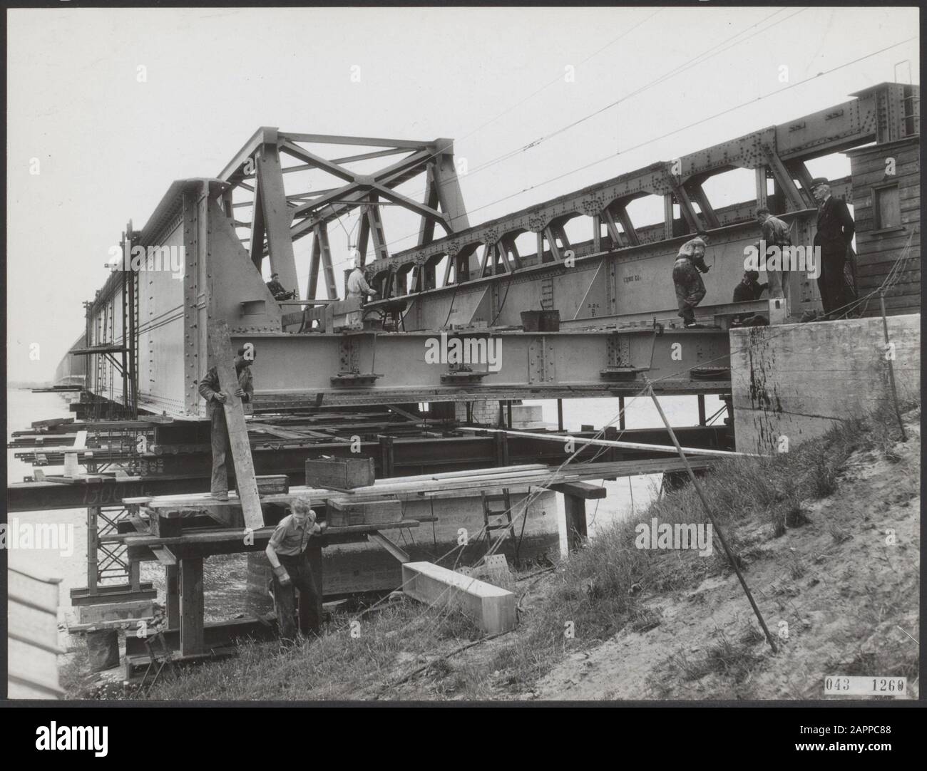 Nachdem nun alle Spannweiten der Moerdijkspoorbrug gelegt wurden, arbeitet man daran, die Einfahrt in Ordnung zu bringen. Hier arbeitet man mir die Doppelspurrampe, die, wenn sie passiert wird, auf dem Gelände des Streckenabschnitts mit noch einspuriger Strecke steht Datum: 23. Juni 1955 Standort: Hollands Diep, Moerdijk Schlüsselwörter: Brücken, Eisenbahn, Wasserbau Stockfoto