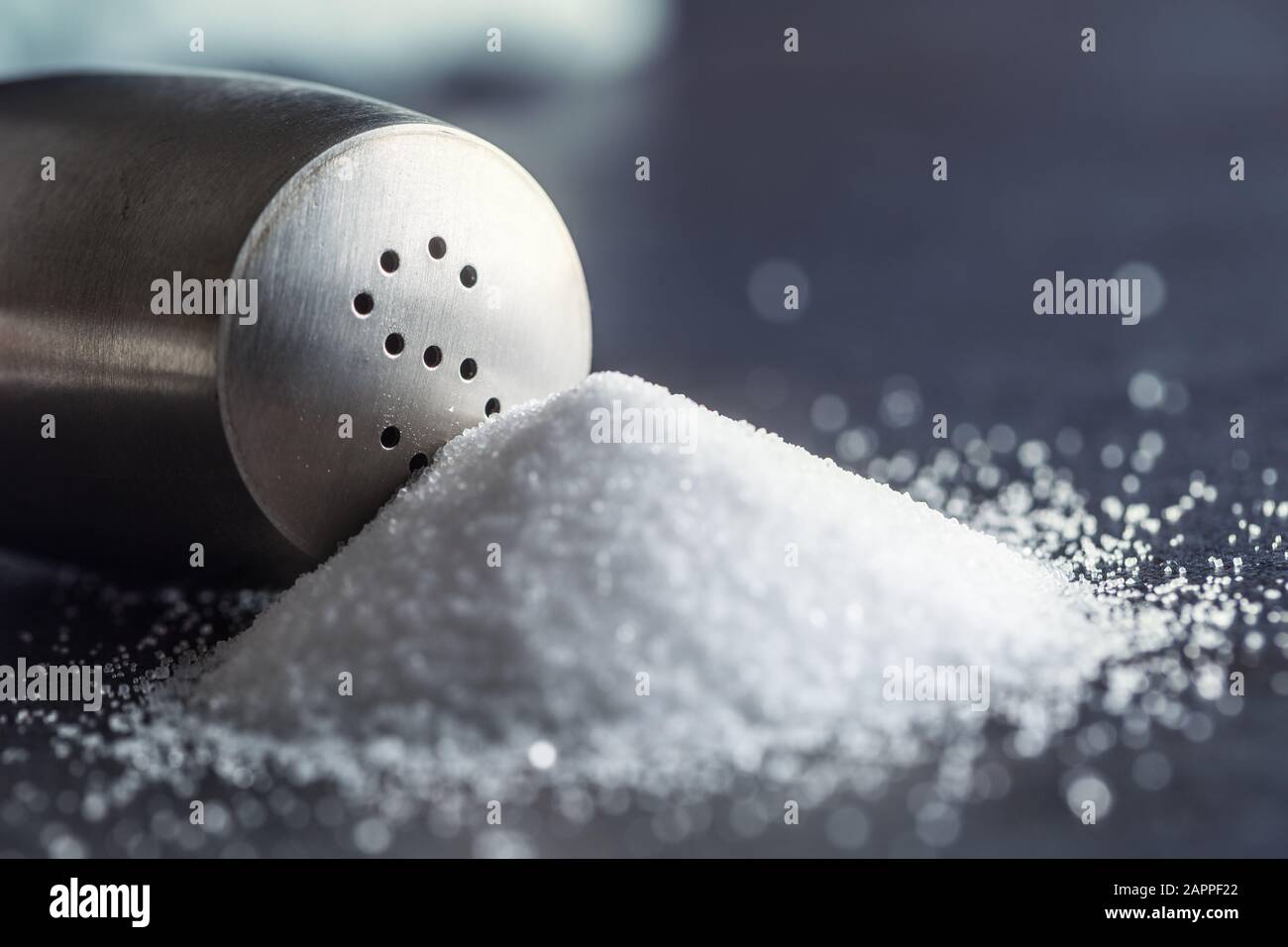 Ausgelaufenes Salz mit stanilem Salzschüttler - Closeup Stockfoto