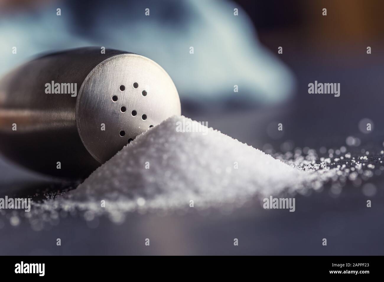 Ausgelaufenes Salz mit stanilem Salzschüttler - Closeup Stockfoto