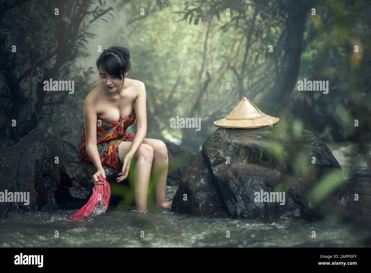 Sexy asiatische Frau, die in Strömen waschen Stockfoto