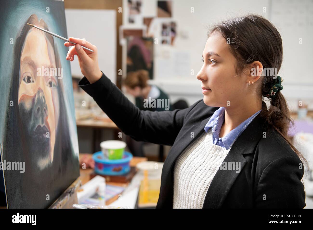 Ein "A"-Level-Kunststudent, das in einer weiterführenden Schule in Großbritannien malt Stockfoto