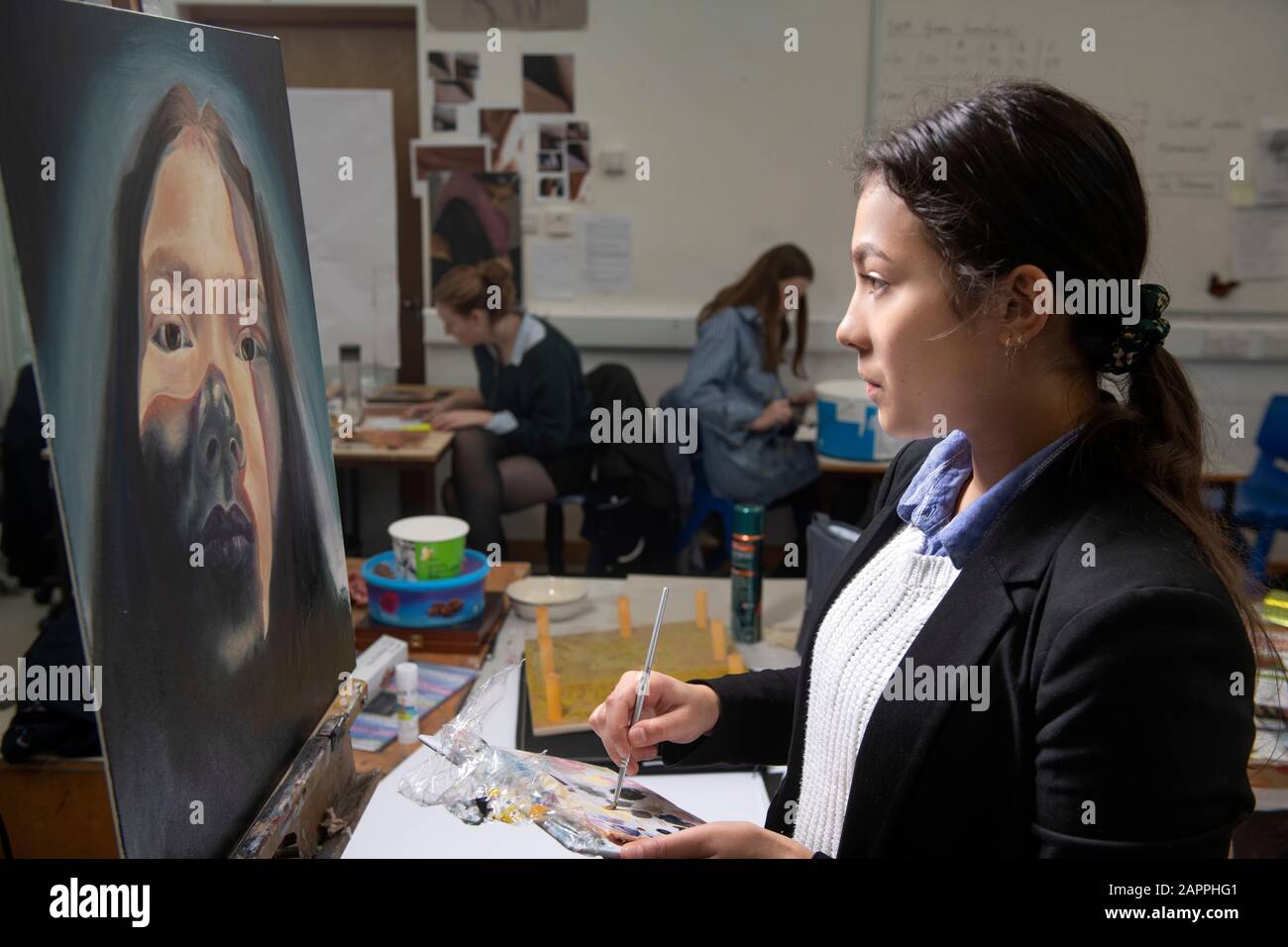 Ein "A"-Level-Kunststudent, das in einer weiterführenden Schule in Großbritannien malt Stockfoto