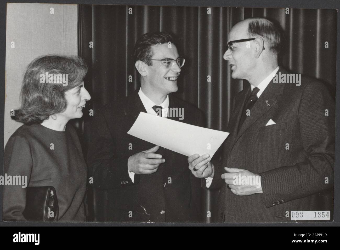 M. Nijhoff-Preis in den Haag. Prof. Dr. De Gaay Fortman, präsident des Prinz-Bernhard-Fonds, überreichte den Preis für Übersetzungen ins Niederländische an Christiaan N. Lissen. Frau Bon. Lijsen blickt über die Schulter ihres Mannes Datum: 27. Januar 1964 Ort: Den Haag, Zuid-Holland Schlüsselwörter: Autoren, Preisverleihungen persönlicher Name: Gaay Fortman, W.F. de, Lijsen, C.N. Stockfoto