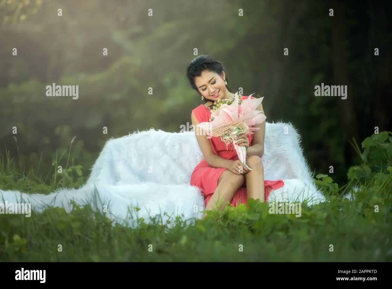 Sofa Frau entspannt genießen Sie Luxus Lifestyle Outdoor-Tag träumen und sehen Blumenstrauß lächelnd fröhlich Stockfoto