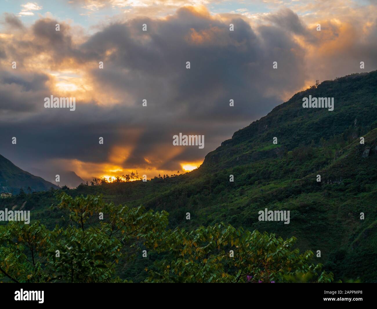 Dramatischer Sonnenuntergang über üppig grünen Bergen Stockfoto