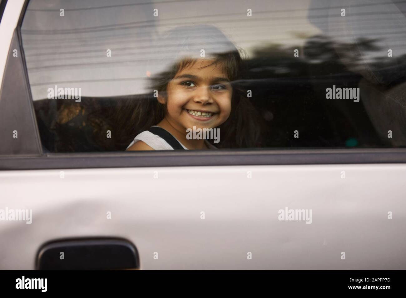 Kleines Mädchen, das durch das Autofenster schaut Stockfoto