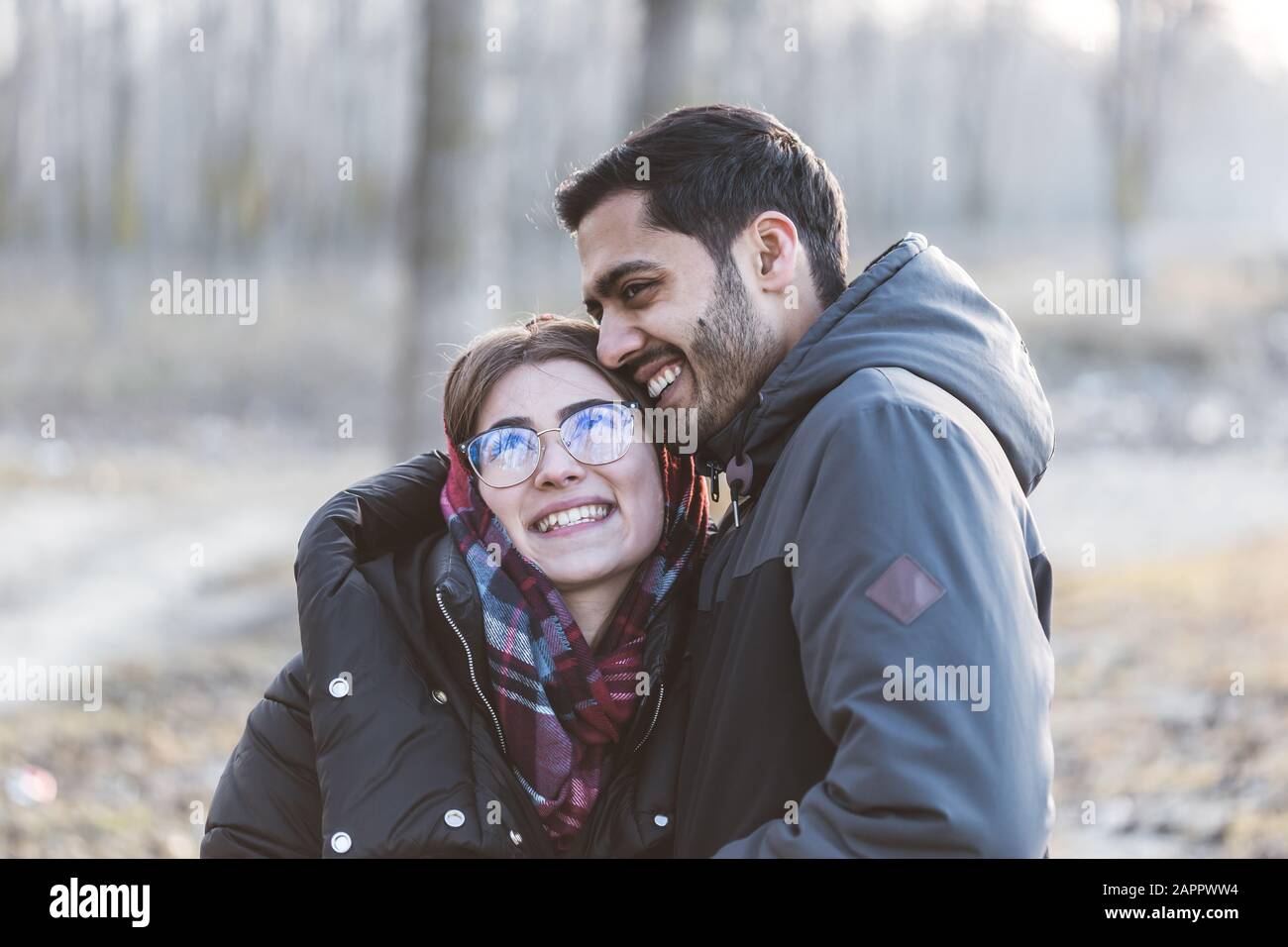 Fröhliches junges fröhliches Paar, das in der Herbstsaison lustige Momente hat und zusammen lacht. Stockfoto