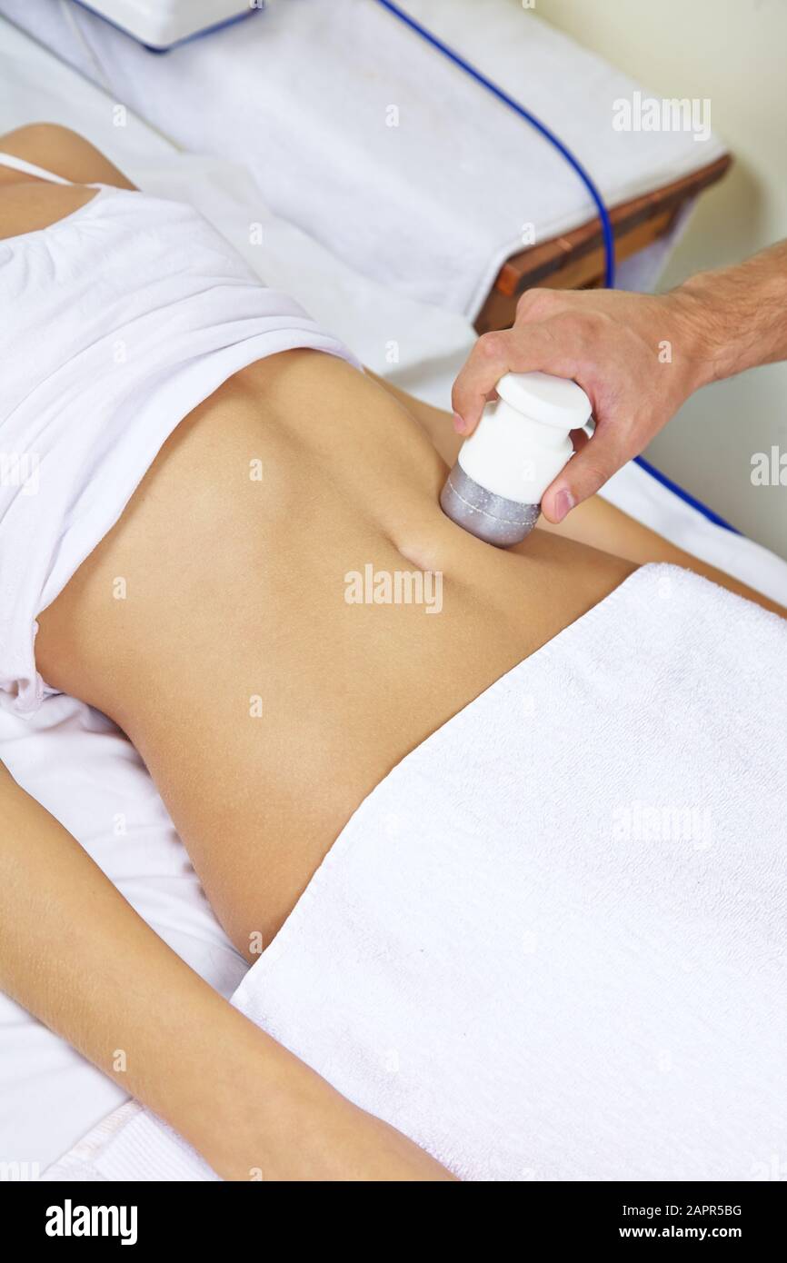 Frau bekommt im Spa eine entspannende elektrische Massage auf dem Bauch Stockfoto