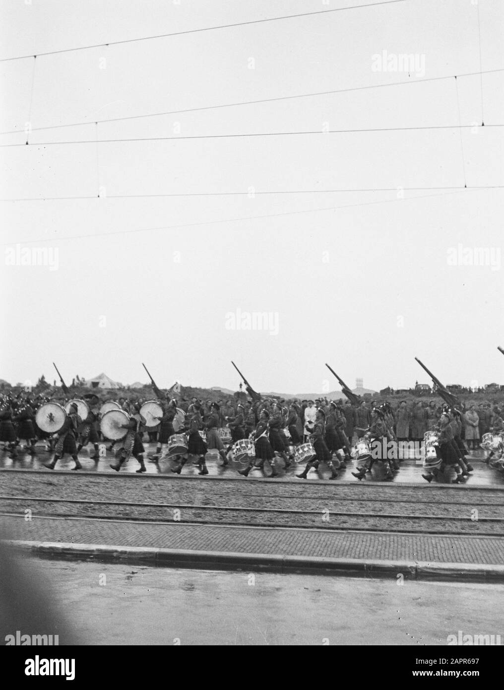 Schottische Militärmusikcorps paradieren entlang von Tramspuren. Im Hintergrund sind die Artillerie-Geschütze aufgestellt Datum: 1945 Stockfoto