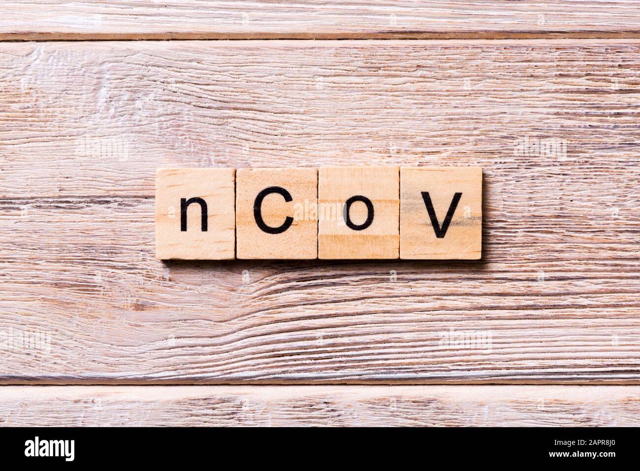 NCoV-Wort auf Holzblock geschrieben. NCoV-Text auf Holztisch für Ihr Desing, Coronavirus Konzept Draufsicht. Stockfoto